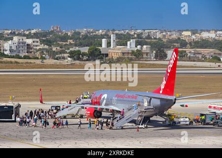 Luqa, Malta - 7. August 2023: Passagiere, die in einen Boeing 737-Urlaubsjet einsteigen, der von Jet2 am internationalen Flughafen Luqa auf der Insel betrieben wird Stockfoto