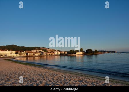 Die atemberaubende Schönheit der Playa de la Ladeira in Baiona bei Sonnenaufgang. Wenn die Sonne aufgeht, taucht ihr goldenes Licht den Sandstrand und das ruhige Wasser und schafft so Stockfoto