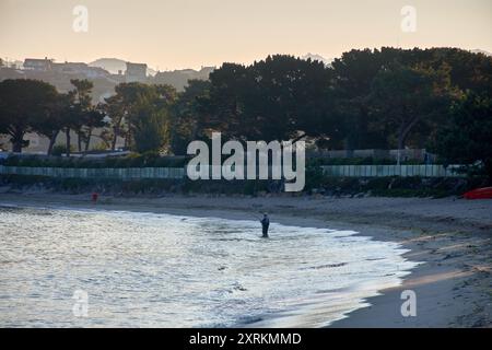 Die atemberaubende Schönheit der Playa de la Ladeira in Baiona bei Sonnenaufgang. Wenn die Sonne aufgeht, taucht ihr goldenes Licht den Sandstrand und das ruhige Wasser und schafft so Stockfoto