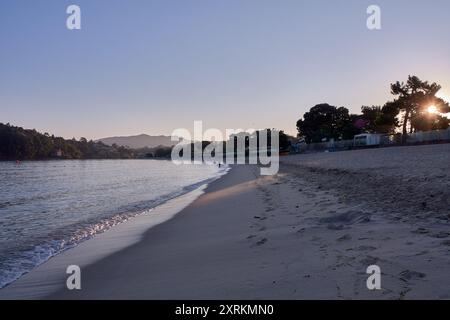 Die atemberaubende Schönheit der Playa de la Ladeira in Baiona bei Sonnenaufgang. Wenn die Sonne aufgeht, taucht ihr goldenes Licht den Sandstrand und das ruhige Wasser und schafft so Stockfoto