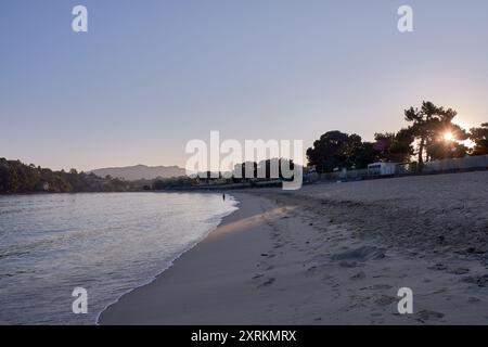 Die atemberaubende Schönheit der Playa de la Ladeira in Baiona bei Sonnenaufgang. Wenn die Sonne aufgeht, taucht ihr goldenes Licht den Sandstrand und das ruhige Wasser und schafft so Stockfoto