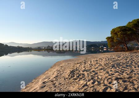 Die atemberaubende Schönheit der Playa de la Ladeira in Baiona bei Sonnenaufgang. Wenn die Sonne aufgeht, taucht ihr goldenes Licht den Sandstrand und das ruhige Wasser und schafft so Stockfoto