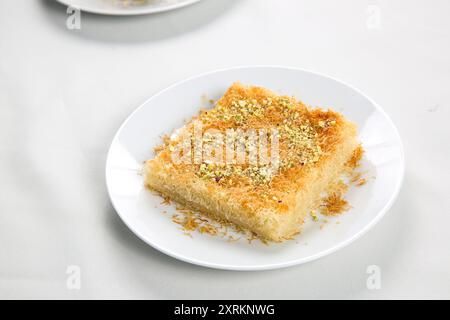 Hausgemachte arabische traditionelle Süßigkeiten, Kunafa oder Knafeh-Nüsse, Käse und Zuckersirup auf Tablett Stockfoto