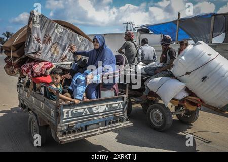 Khan Younis, Palästinensische Gebiete. August 2024. Die Palästinenser tragen ihre Sachen, als sie aus Hamad nach Al-Mawasi fliehen, nachdem die israelische Armee Flugblätter abgegeben hatte, in denen sie die Bewohner einer nördlichen Nachbarschaft in Khan Younis aufgefordert hatten, unmittelbar vor einer neuen Militäroperation im Gazastreifen zu evakuieren. Abed Rahim Khatib/dpa/Alamy Live News Stockfoto