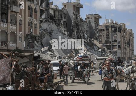 Khan Younis, Palästinensische Gebiete. August 2024. Die Palästinenser tragen ihre Sachen, als sie aus Hamad nach Al-Mawasi fliehen, nachdem die israelische Armee Flugblätter abgegeben hatte, in denen sie die Bewohner einer nördlichen Nachbarschaft in Khan Younis aufgefordert hatten, unmittelbar vor einer neuen Militäroperation im Gazastreifen zu evakuieren. Abed Rahim Khatib/dpa/Alamy Live News Stockfoto