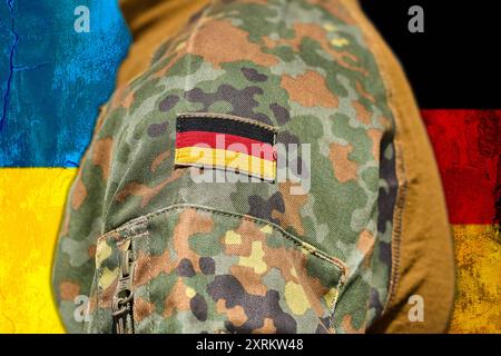 11. August 2024: Ein Soldat der Bundeswehr steht vor der ukrainischen Flagge. Symbolisches Bild der Unterstützung Deutschlands im Krieg zwischen Russland und der Ukraine. FOTOMONTAGE *** ein Soldat der deutschen Bundeswehr steht vor der ukrainischen Flagge. Symbolbild Unterstützung von Deutschland im Russland und Ukraine Krieg. FOTOMONTAGE Stockfoto