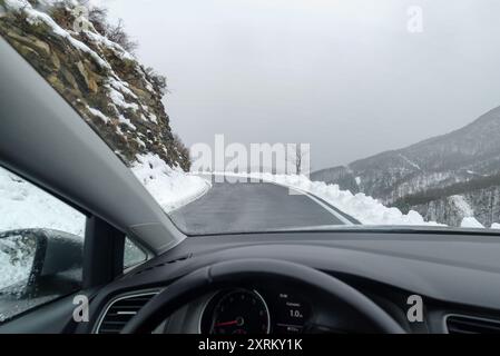 Aus dem Inneren des Autos die atemberaubende, hochgelegene Winterstraße entlang der ligurischen Alpen, Italien Stockfoto