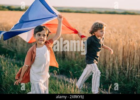 Niedliche Kleine Jungen - Französischer Patriot-Kinder, Die Mit Nationalflagge Auf Dem Offenen Gelände Laufen Stockfoto