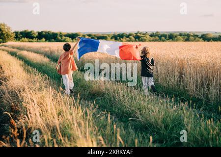 Niedliche Kleine Jungen - Französischer Patriot-Kinder, Die Mit Nationalflagge Auf Dem Offenen Gelände Laufen Stockfoto