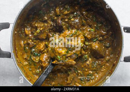 Blick von oben auf die nigerianische Ogbono-Suppe in einem Topf, Blick von oben auf Ogbono-Suppe mit verschiedenen Fleischsorten in einem Suppentopf, nigerianische Ogbono- und Okra-Suppe Stockfoto