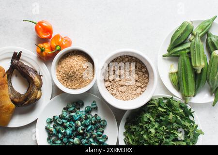 Overhead-Ansicht der Zutaten für die Zubereitung von Ogbono-Suppe auf einer Granitarbeitsfläche, Draufsicht der Miese und anstelle der Zutaten für die Zubereitung von Ogbono- und Okro-Suppe, Stockfoto