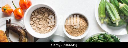 Overhead-Ansicht der Zutaten für die Zubereitung von Ogbono-Suppe auf einer Granitarbeitsfläche, Draufsicht der Miese und anstelle der Zutaten für die Zubereitung von Ogbono- und Okro-Suppe, Stockfoto