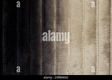 Schwarz mit Übergang zu grau gestreiftem weichem Wildleder als Hintergrund, schwarzer Hintergrund, schwarzer Stoff Stockfoto