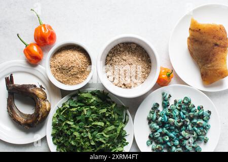 Overhead-Ansicht der Zutaten für die Zubereitung von Ogbono-Suppe auf einer Granitarbeitsfläche, Draufsicht der Miese und anstelle der Zutaten für die Zubereitung von Ogbono- und Okro-Suppe, Stockfoto