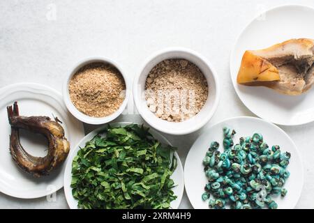 Overhead-Ansicht der Zutaten für die Zubereitung von Ogbono-Suppe auf einer Granitarbeitsfläche, Draufsicht der Miese und anstelle der Zutaten für die Zubereitung von Ogbono- und Okro-Suppe, Stockfoto