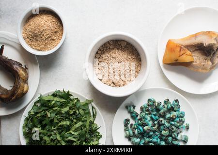 Overhead-Ansicht der Zutaten für die Zubereitung von Ogbono-Suppe auf einer Granitarbeitsfläche, Draufsicht der Miese und anstelle der Zutaten für die Zubereitung von Ogbono- und Okro-Suppe, Stockfoto