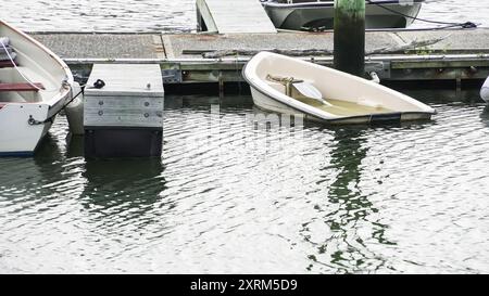 Kleine Boote legten an einem Yachthafen an und überschwemmten teilweise in ruhigem Wasser an einem bewölkten Tag mit Kopierraum Stockfoto