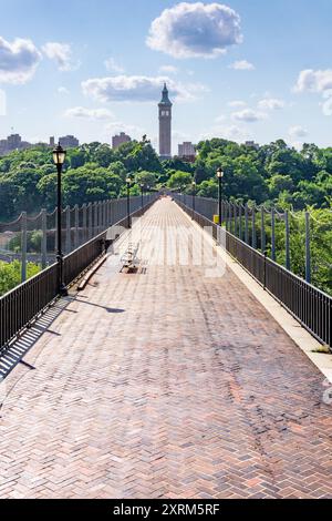 Bronx, NY - USA - 10. August 2024 die High Bridge, die älteste stehende Brücke von NYC, erstreckt sich über üppiges Grün unter hellem Himmel. Der Turm in der Ferne Stockfoto