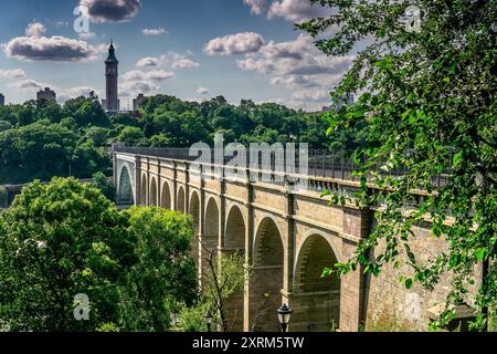 Bronx, NY - USA - 10. August 2024 die High Bridge, die älteste stehende Brücke von NYC, erstreckt sich über üppiges Grün unter hellem Himmel. Der Turm in der Ferne Stockfoto