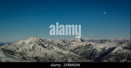 Im Winter steigt der Vollmond über schneebedeckten Gipfeln in der Ancares Mountain Range in Cervantes Lugo Galicien auf Stockfoto