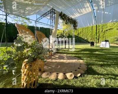 Entdecken Sie den Zauber eines rustikalen Blumenaltars, eingebettet in das heitere Heiligtum der Natur. Tauschen Sie Gelübde in einer atemberaubenden Umgebung, umgeben von üppigen Bäumen. Stockfoto