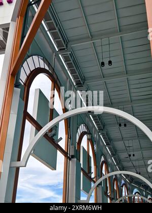 Weißes Gebäude mit Bogenfenstern und blauen Zierleisten steht hoch unter klarem Himmel Stockfoto