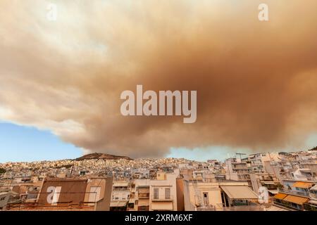 Dicker Rauch von Waldbränden in den Regionen Varvanas und Grammatiko umhüllt den Himmel über Athen, Griechenland, und schafft eine dramatische und bedrohliche Szene Stockfoto