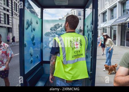 London, England, Großbritannien. August 2024. Ein Arbeiter der Stadt London vermisst eine Polizeiwache mit einem neuen Banksy-Kunstwerk in der Stadt London. Das Kunstwerk, das eine Fischschule darstellt, ist das siebte neue Kunstwerk des schwer fassbaren Straßenkünstlers in so vielen Tagen in London. (Kreditbild: © Vuk Valcic/ZUMA Press Wire) NUR REDAKTIONELLE VERWENDUNG! Nicht für kommerzielle ZWECKE! Quelle: ZUMA Press, Inc./Alamy Live News Stockfoto