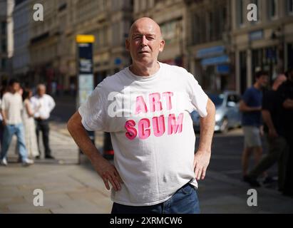 Der Londoner Künstler Jim Walsh kritisiert ein neues Werk von Banksy, das ein Design von schwimmendem Fisch auf einer Polizeibox in der City of London zeigt. Das Design der Polizeibox unterscheidet sich von Banksys früheren Silhouettendesigns, da die Fischschule mit mehr Details und Ton auf die Polizeibox gemalt wurde. Es ist das siebte Tier-Thema-Stück, das der schwer fassbare Straßenkünstler diese Woche beansprucht, indem er ein Foto der Kunstwerke auf seinem Instagram postet. Bilddatum: Sonntag, 11. August 2024. Stockfoto