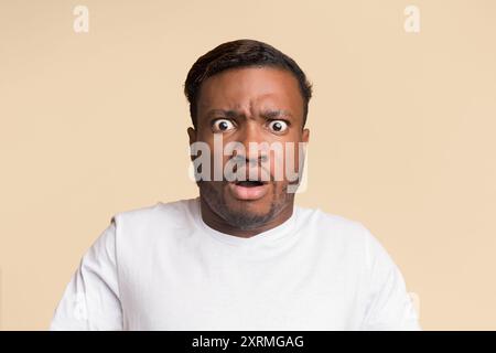 Afro Mann an der Kamera, Studio Shot Geschockt Stockfoto