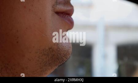 Männliches Kinn mit Stoppeln. Dünne Stoppeln im Gesicht eines Mannes aus Makroperspektive. Stockfoto