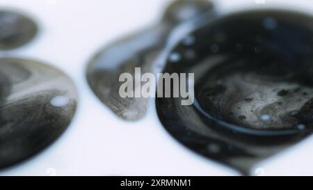 Blasen unscharf machen. Glitzerfleck. Unschärfe schwarz weiß schimmernde Partikel Tröpfchen schwimmende Acrylstruktur Tinte Wasserfluss abstrakte Kunst Hintergrund. Stockfoto