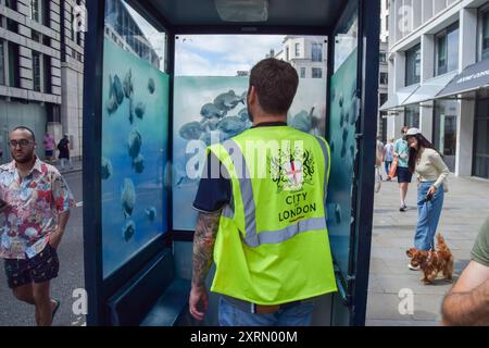 London, England, Großbritannien. August 2024. Ein Arbeiter verspeist die Polizeiwache in London mit dem neuen Banksy-Kunstwerk. Das Kunstwerk, das eine Fischschule darstellt, ist das siebte neue Kunstwerk des schwer fassbaren Straßenkünstlers in so vielen Tagen in London. (Kreditbild: © Vuk Valcic/ZUMA Press Wire) NUR REDAKTIONELLE VERWENDUNG! Nicht für kommerzielle ZWECKE! Quelle: ZUMA Press, Inc./Alamy Live News Stockfoto
