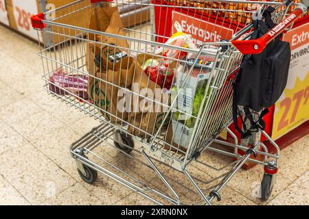 Nahansicht eines Einkaufswagens, der mit verschiedenen Produkten in einem Supermarkt gefüllt ist. Schweden. Uppsala. Stockfoto