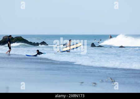 Deal, New Jersey - 10. August 2024: Surfer surfen auf den Resten des Hurrikans Debby in The Waters off Deal Stockfoto