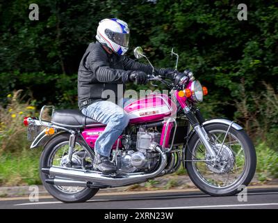 Potterspury, Northants, UK - 11. August 2024: 1972 rosa Suzuki 738 ccm Motorrad auf einer britischen Straße Stockfoto