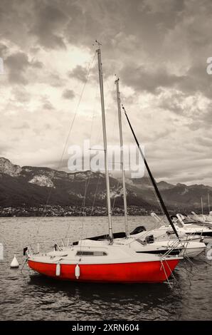 Yachten legen bei Sonnenuntergang am Annecy Lake an. Annecy Lake ist eines der beliebtesten französischen Resorts. Retro-Foto im Alter. Stockfoto