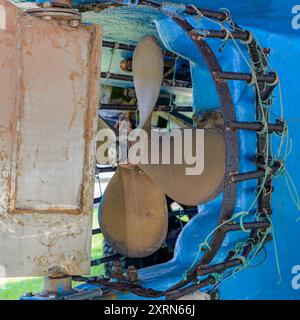 Eine Nahaufnahme des Propellers auf einem Fischerboot mit einem rostigen Metallmantel. Die Verkleidung verhindert, dass sich Seile usw. im Propeller verfangen. Stockfoto