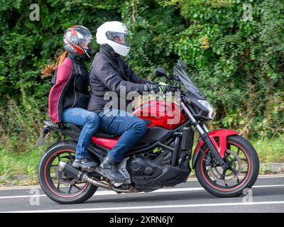 Potterspury, Northants, Großbritannien - 11. August 2024: Mann und Sozius fahren auf einem Honda NC-Motorrad von 2016 auf einer britischen Straße Stockfoto