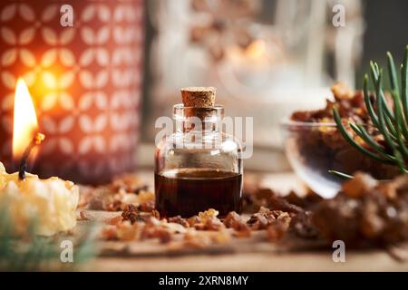 Ätherisches Myrrhenöl und Harz mit Kerzen im Hintergrund Stockfoto