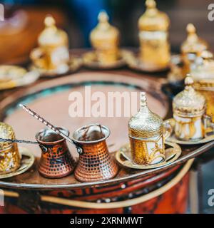 Traditionelles türkisches Kaffeeset mit kunstvollen goldenen Tassen und Kupfertöpfen Stockfoto