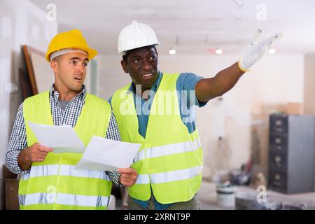Vorarbeiter unzufrieden mit der Qualität der Reparaturarbeiten der Baumeister Nahaufnahme Stockfoto