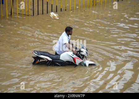 Neu-Delhi, Indien. August 2024. GURUGRAM, INDIEN - 11. AUGUST: Ein Mann zieht sein Fahrrad aus einer wasserdichten Strecke, während der starke Regen an der Sector-47 Road in der Nähe von Subhash Chowk am 11. August 2024 in Gurugram, Indien. (Foto: Parveen Kumar/Hindustan Times/SIPA USA) Credit: SIPA USA/Alamy Live News Stockfoto