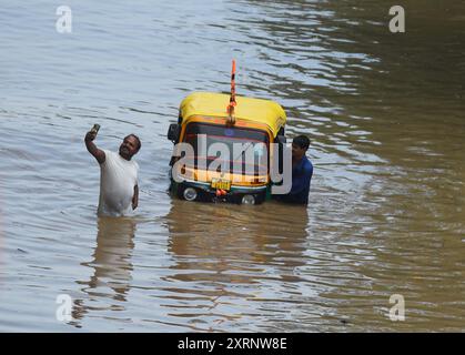 Neu-Delhi, Indien. August 2024. GURUGRAM, INDIEN – 11. AUGUST: Ein Mann zieht seine Auto-Rikscha aus einem wasserdurchtränkten Abschnitt während des starken Regens an der Sector-47 Road in der Nähe von Subhash Chowk, am 11. August 2024 in Gurugram, Indien. (Foto: Parveen Kumar/Hindustan Times/SIPA USA) Credit: SIPA USA/Alamy Live News Stockfoto