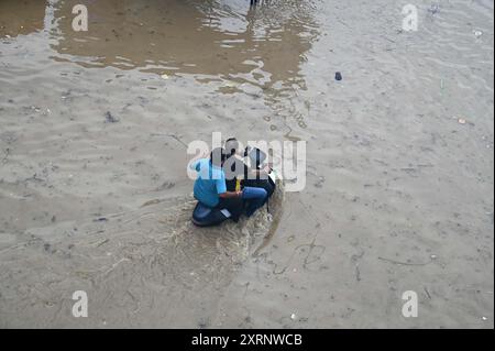 Neu-Delhi, Indien. August 2024. GURUGRAM, INDIEN - 11. AUGUST: Ein Mann zieht sein Fahrrad aus einer wasserdichten Strecke, während der starke Regen an der Sector-47 Road in der Nähe von Subhash Chowk am 11. August 2024 in Gurugram, Indien. (Foto: Parveen Kumar/Hindustan Times/SIPA USA) Credit: SIPA USA/Alamy Live News Stockfoto