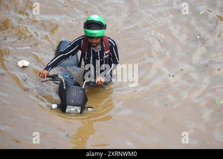 Neu-Delhi, Indien. August 2024. GURUGRAM, INDIEN - 11. AUGUST: Ein Mann zieht sein Fahrrad aus einer wasserdichten Strecke, während der starke Regen an der Sector-47 Road in der Nähe von Subhash Chowk am 11. August 2024 in Gurugram, Indien. (Foto: Parveen Kumar/Hindustan Times/SIPA USA) Credit: SIPA USA/Alamy Live News Stockfoto