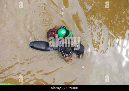 Neu-Delhi, Indien. August 2024. GURUGRAM, INDIEN - 11. AUGUST: Ein Mann zieht sein Fahrrad aus einer wasserdichten Strecke, während der starke Regen an der Sector-47 Road in der Nähe von Subhash Chowk am 11. August 2024 in Gurugram, Indien. (Foto: Parveen Kumar/Hindustan Times/SIPA USA) Credit: SIPA USA/Alamy Live News Stockfoto