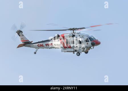 REDDING KALIFORNIEN – 10. AUGUST 2024 – Ein CALFIRE Sikorsky S-70 „Firehawk“ Hubschrauber im Flug über Mary Lake, der sich auf die Wasseraufnahme vorbereitet. Stockfoto