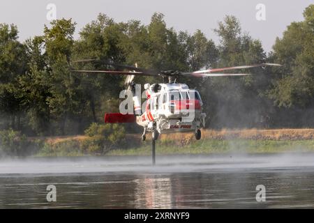 REDDING KALIFORNIEN – 10. AUGUST 2024 – Ein CALFIRE Sikorsky S-70 „Firehawk“ Hubschrauber pumpt Wasser aus dem Mary Lake, um das nahe gelegene Feuer zu bekämpfen. Stockfoto