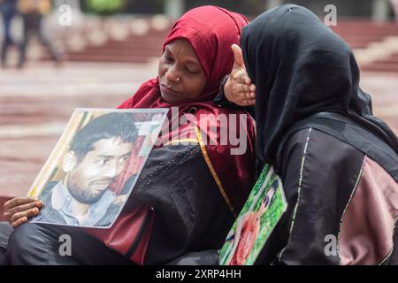 Dhaka, Bangladesch. August 2024. Familienangehörige von Opfern des Verschwindenlassens, die angeblich von Regierungsbehörden während der Herrschaft der Awami-Liga begangen wurden, halten Porträts ihrer verschwundenen Verwandten, während sie vor dem Shaheed Minar um ihre Rückkehr bitten. Verwandte der Opfer des Verschwindenlassens haben die Rückgabe ihrer Angehörigen gefordert. Die Veranstaltung wurde von der sozialen Organisation „Mayer Daak“ organisiert. Quelle: SOPA Images Limited/Alamy Live News Stockfoto